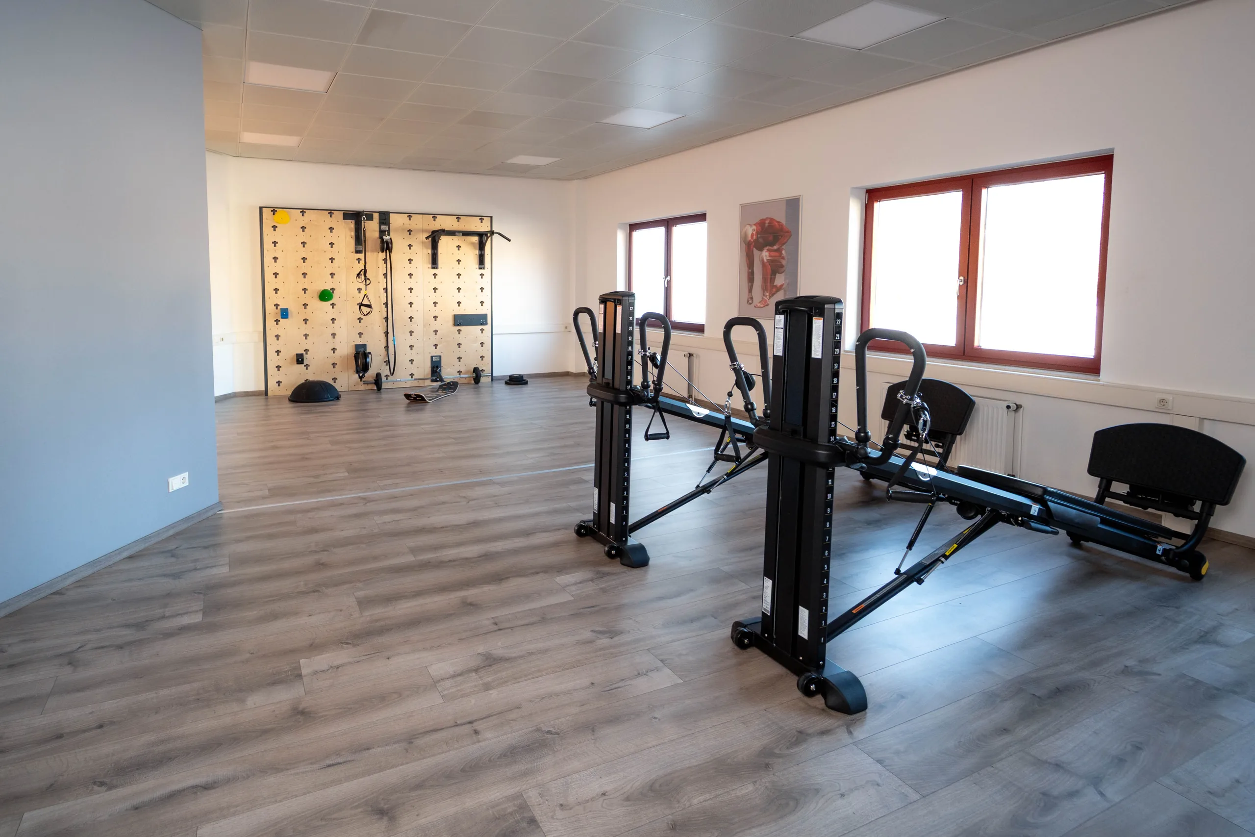Heller Trainingsraum mit funktioneller Trainingswand und Zuggeräten
