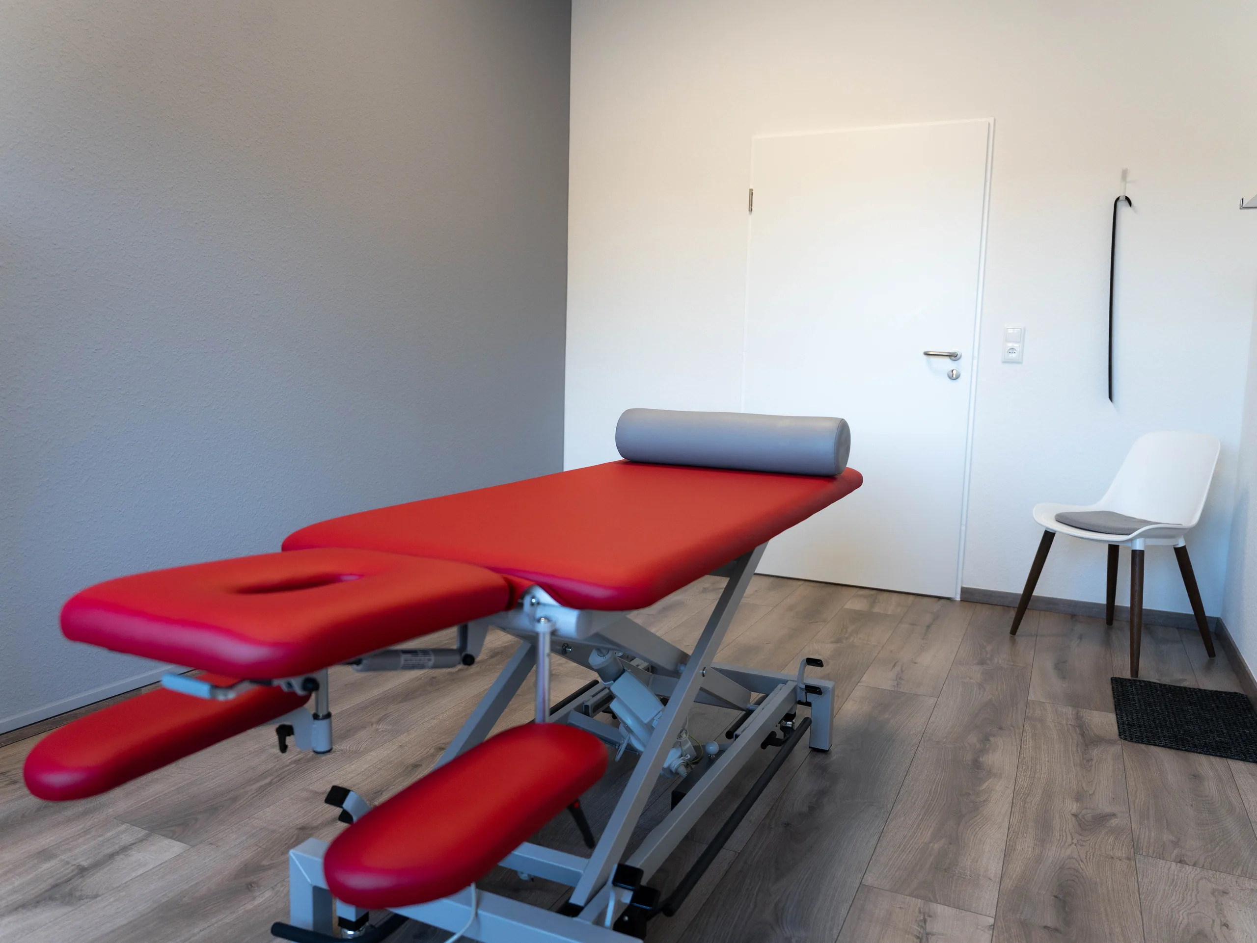 Behandlungsraum mit kirschroter Liege